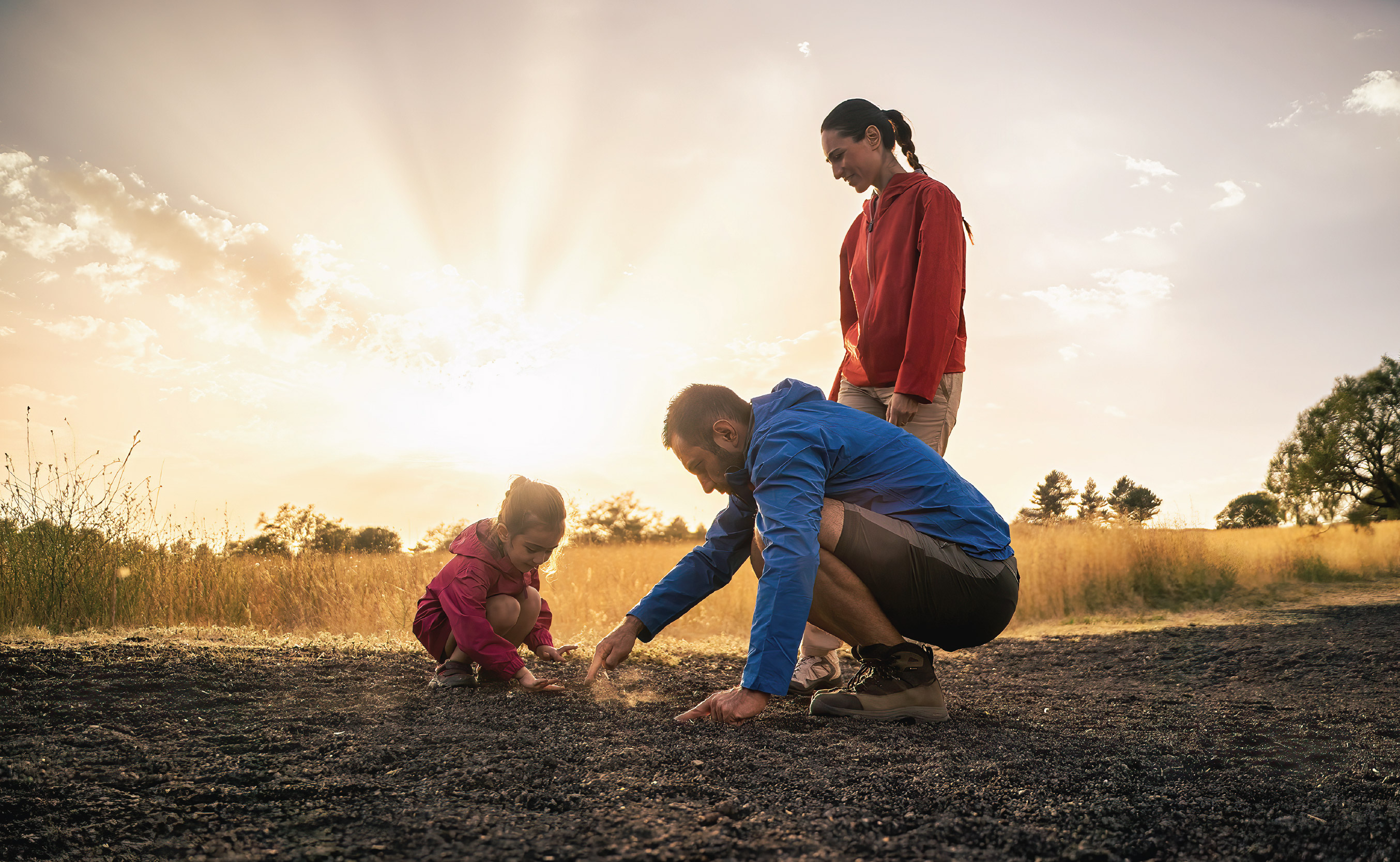 Happy family group sitting in field